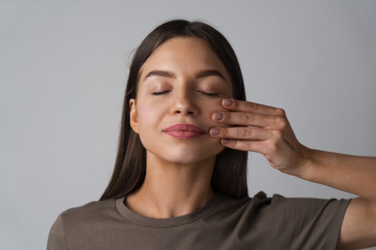 A woman pressing her fingers against her cheek