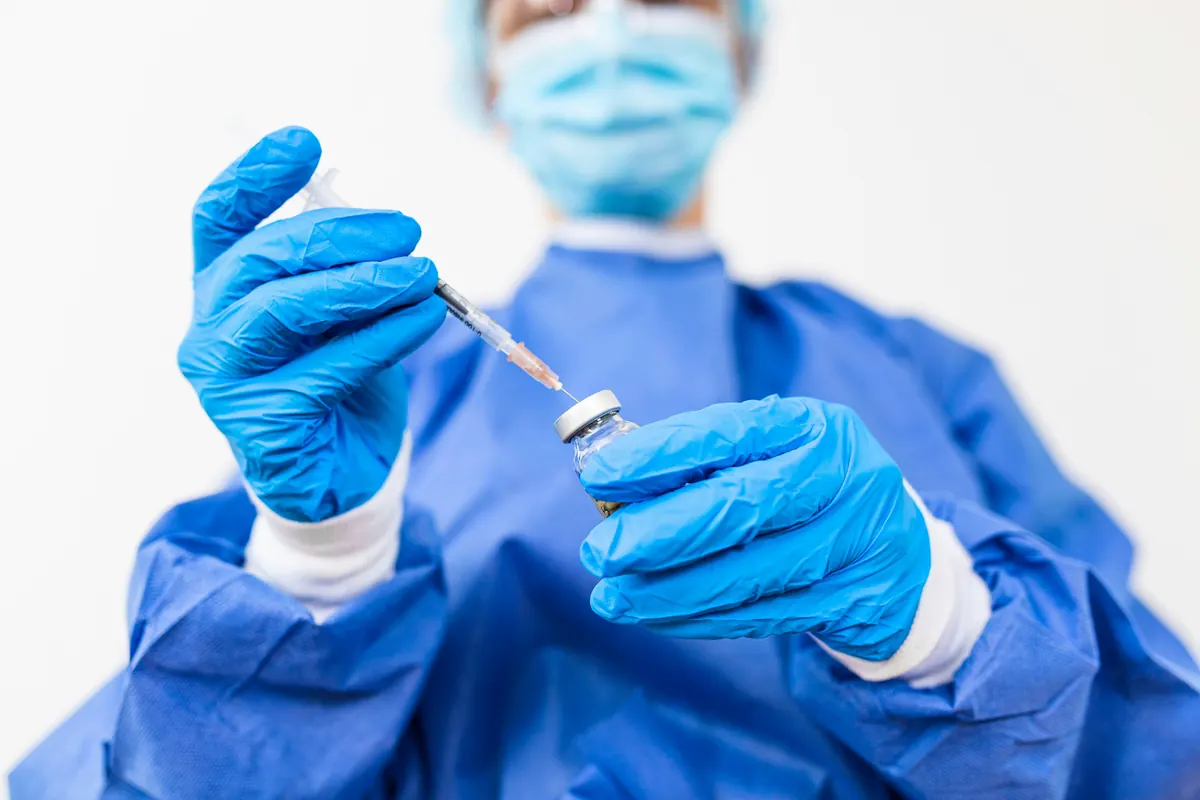 A patient in a surgical cap having treatment points marked on the face with a fine applicator