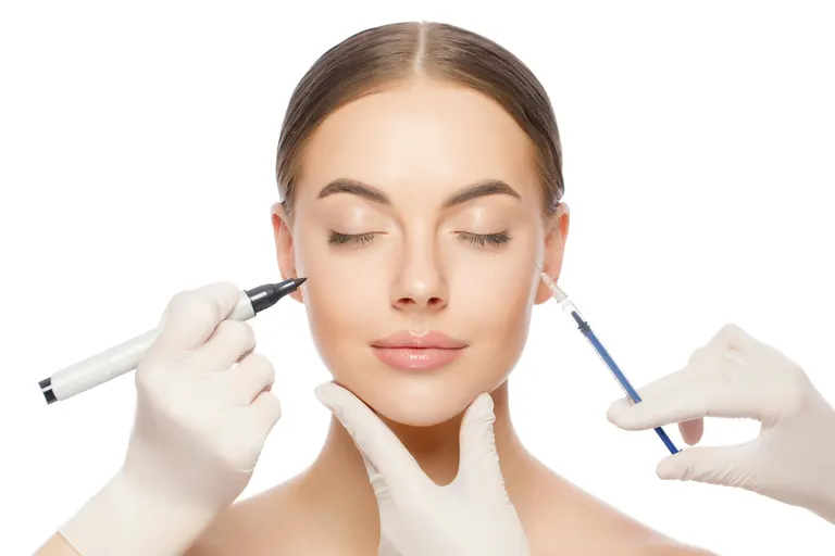 A woman's face with her eyes closed, a gloved hand holding a marking pencil at one outer eye and another holding a syringe at the other